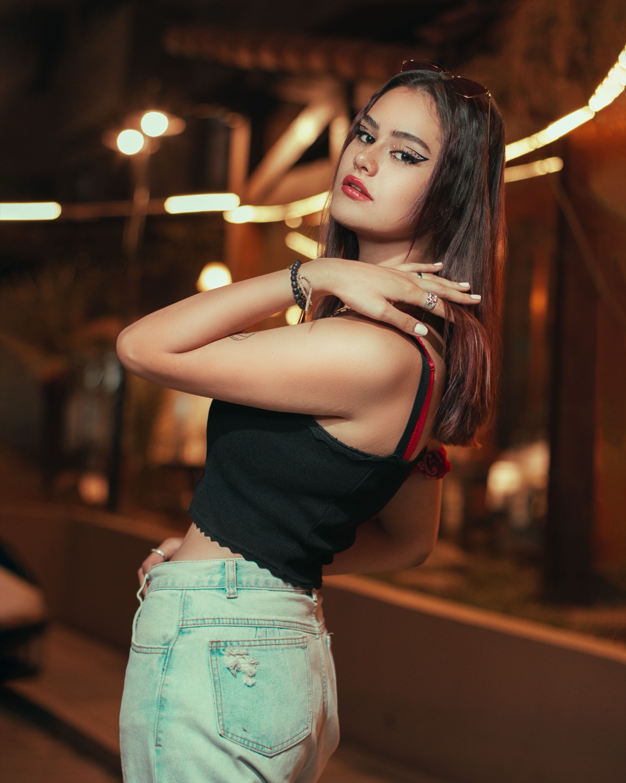 Woman at night with warm city lights behind her